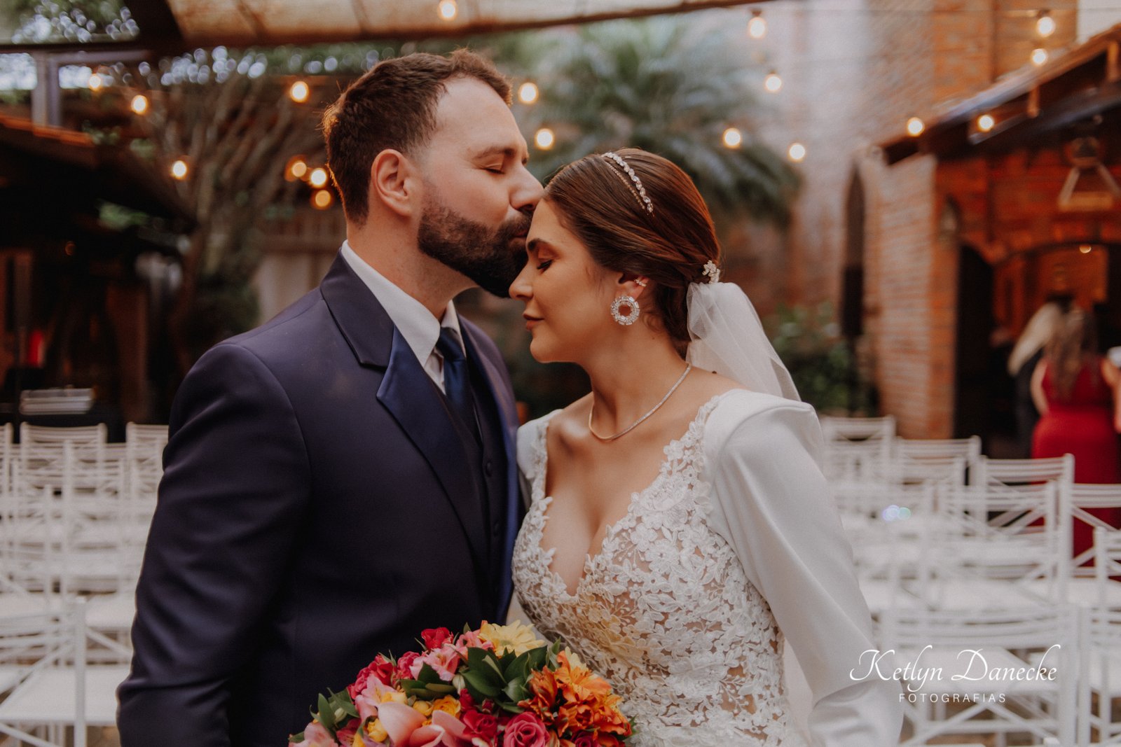 Noivo beijando a testa da noiva durante o casamento